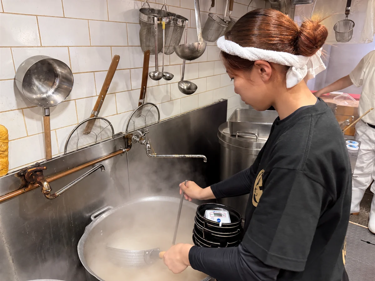 厨房で麺をゆでる調理風景